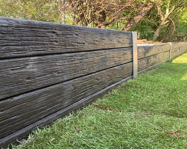 Close-up of a dark woodgrain-finish concrete sleeper retaining wall