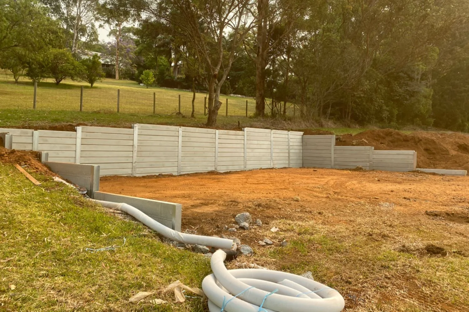 Concrete sleeper retaining wall under construction on a large block