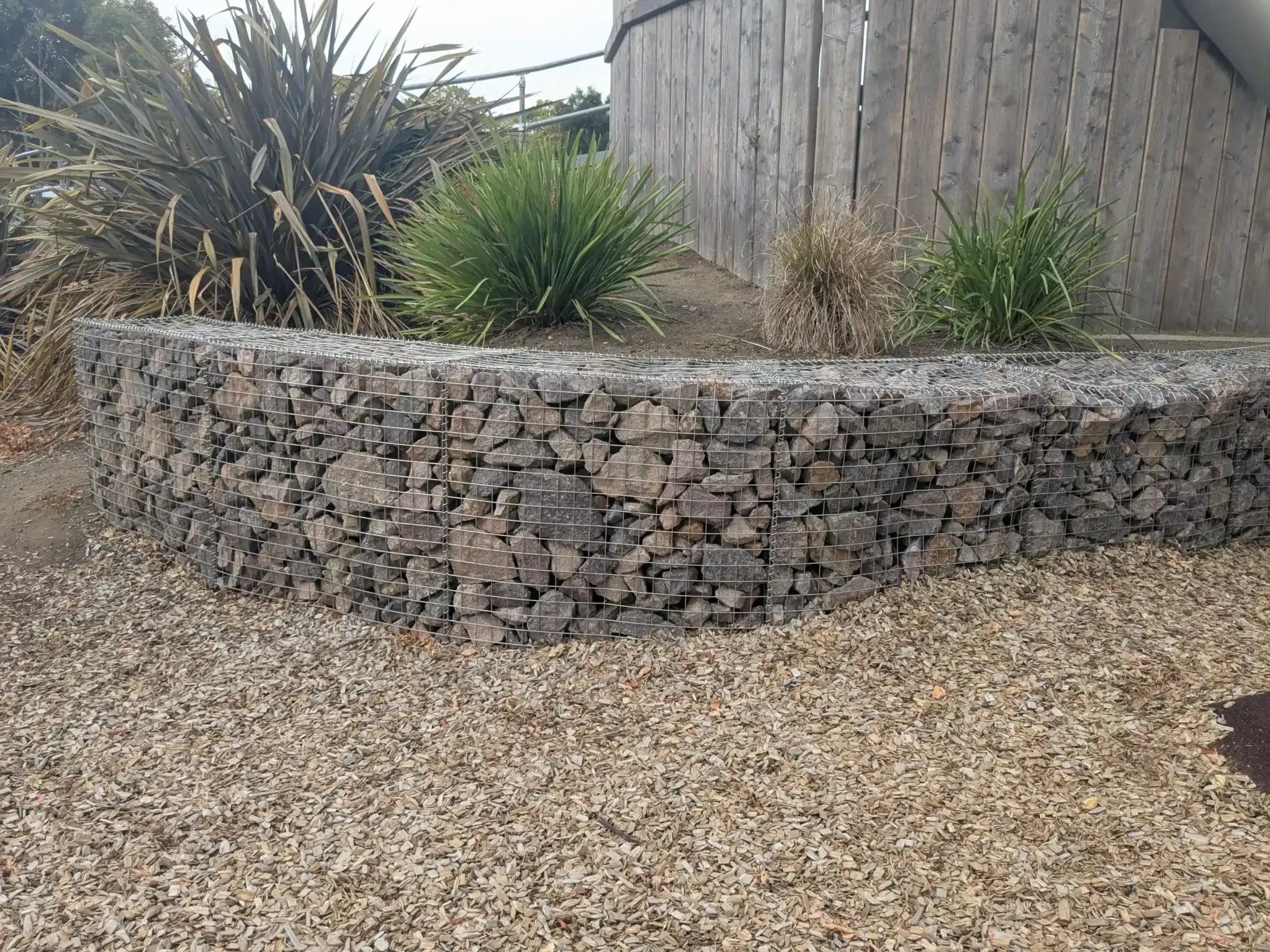 Gabion retaining wall filled with rounded river stones
