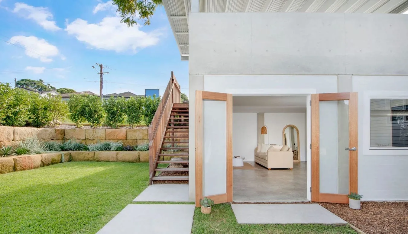 Backyard renovation featuring a sandstone-block retaining wall