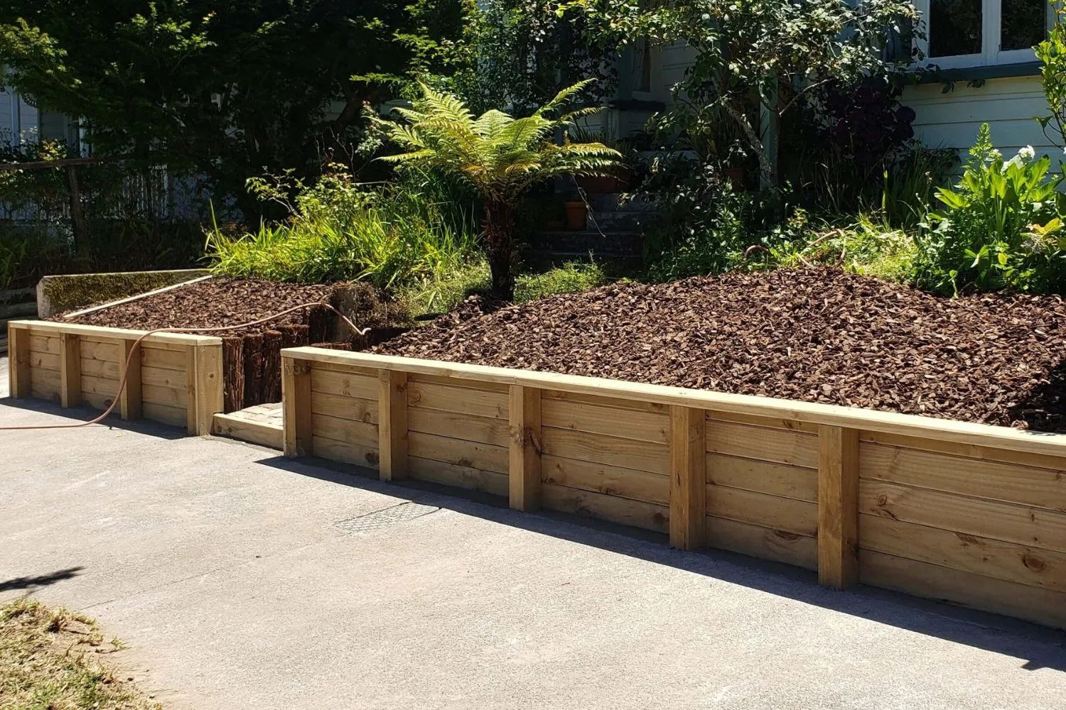 Curved treated pine timber retaining wall around a raised garden bed